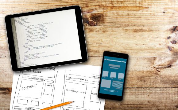 Website Wireframe Sketch And Programming Code On Digital Tablet